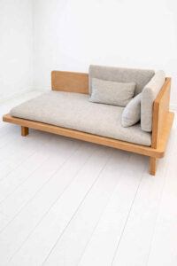 Daybed med grå hynder og lyst træ